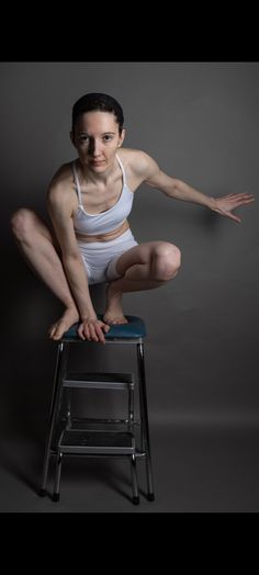 a woman sitting on top of a stool