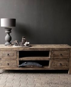 a wooden table with drawers and a lamp next to it on a carpeted floor