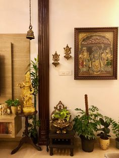 there are many plants and statues in the corner of this room with paintings on the wall