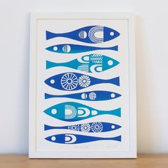 a blue and white art print with fish on it's sides, in front of a wall