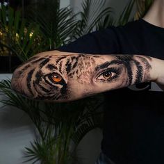 a person with a tiger tattoo on their arm and the eyes are glowing in the dark