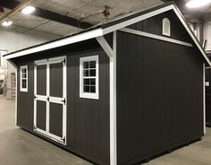 a storage shed in a warehouse with windows and doors on the side, next to other garages