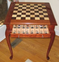 a wooden table with chess pieces on it in front of a window and a radiator