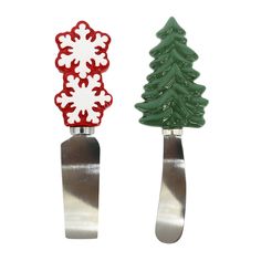 two knives with christmas trees on them sitting side - by - side in front of each other