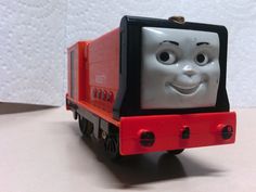 a red and black toy truck with a smiling face