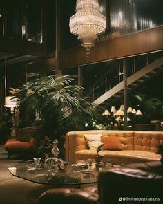 a living room filled with lots of furniture and a chandelier hanging from the ceiling