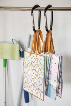 three bags hanging on a clothes line in a room