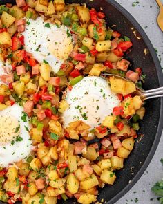 two fried eggs on top of potatoes in a skillet with parsley and pepper