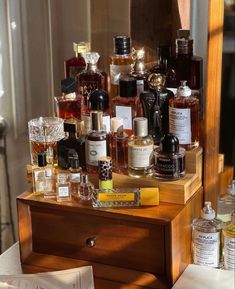 an assortment of perfumes on display in front of a mirror