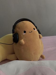 a stuffed animal with headphones laying on a bed