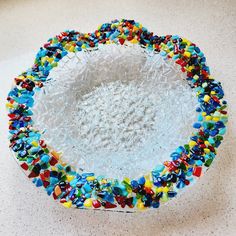 a glass bowl filled with lots of different colored sprinkles on top of a table