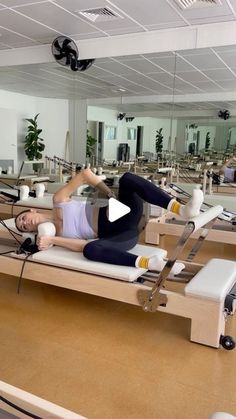 a woman is doing pivots on a rowing machine in a room with mirrors