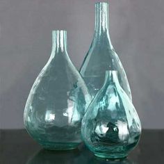 two glass vases sitting on top of a table