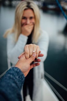 two people holding hands in front of the camera, one is pointing at the other