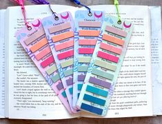 five pastel colored bookmarks on top of an open book