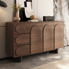 a wooden cabinet sitting next to a wall with pictures on it's sideboard