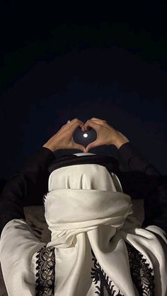 a person with their hands in the shape of a heart