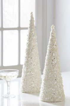 two white christmas trees sitting on top of a table