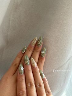 a woman's hands with gold and silver nail polish