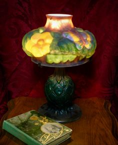 a lamp sitting on top of a table next to a book