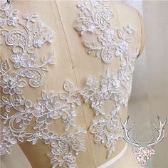 the back of a dress with white lace on it and a deer's antlers