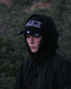 a man in a black hoodie holding a white frisbee