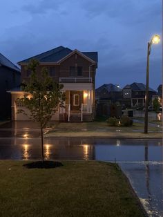 a house is lit up at night in the rain