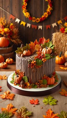 there is a cake decorated with leaves and pumpkins on the table next to other decorations