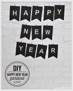 black and white happy new year banner hanging on a brick wall next to a sign that says diy happy new year garland