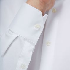 The James solid OoohCotton shirt features a point collar, adjustable notched cuffs, mother-of-pearl buttons, and a curved hem perfect for wearing tucked or untucked. OoohCotton is a performance, double-mercerized, wrinkle-resistant, breathable, and easy-care cotton blend with 8-way stretch, quick-dry, and thermal comfort properties. White Blouse With Concealed Placket And Fold-down Collar, White Business Blouse With Placket, White Cuff Shirt For Semi-formal Occasions, White Blouse With Placket For Business, Classic White Shirt With Covered Buttons, White Shirt With Cuffed Sleeves For Business, Classic White Blouse With Concealed Placket, Classic White Blouse With Hidden Buttons, Classic White Blouse With Hidden Button Closure