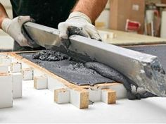 a man is working with cement on the floor