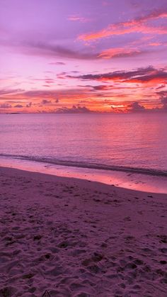 a purple sunset over the ocean and beach