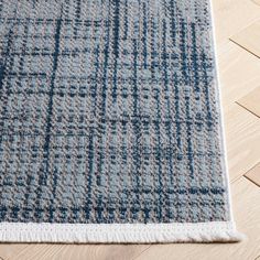 a blue and white rug on top of a wooden floor