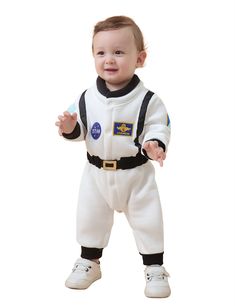 a baby in an astronaut suit holding a toothbrush