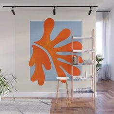 an orange and blue painting on a wall in a room with wooden floors, white walls and flooring