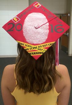 a woman wearing a red graduation cap with the fingerprints and words on it