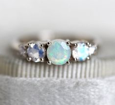 three stone ring with opal and white topazte stones in the middle, set on