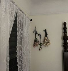 there are flowers on the wall next to the window in this room with sheer curtains