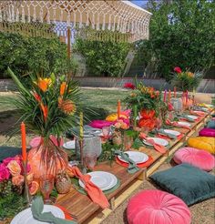 an outdoor table set up with plates and place settings