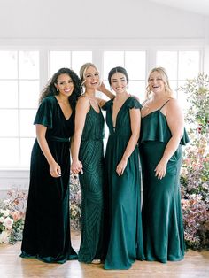 the bridesmaids pose in their emerald green dresses