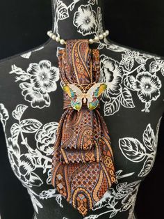 This Brown, Baby Blue and Orange Paisley Necktie Necklace is made with a (Barry Wang) woven silk tie, and features a Brown, Baby Blue and Orange Rhinestone Butterfly Brooch strung on your choice of an adjustable Rosary Chain Ribbon Tie Pearl Necklace or an adjustable Elastic Band. The soft, comfortable fabric sits perfectly on any size chest, while the adjustable necklace feature allows you to customize the fit to your liking. Measuring at a versatile length, this necktie necklace is designed to Necktie Necklace Diy, Elegant Multicolor Brooches For Evening, Elegant Multicolor Brooches For Formal Occasions, Elegant Brown Formal Brooches, Tie Projects, Necktie Necklace, Tie Necklace, Diy Fashion Hacks, Women Ties