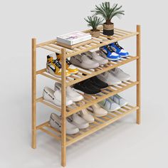 a wooden shoe rack with several pairs of shoes on it and a potted plant next to it