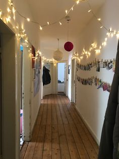 the hallway is decorated with string lights and pictures on the wall, along with other decorations