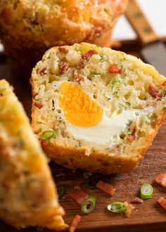 a muffin with an egg in it on a cutting board next to other muffins