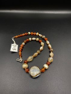 The beautiful mala necklace consist of Himalayan luk Mik or we called them magic eye bead as well in the center of the mala necklace with Banded Agate and carnelian Luk Mik means (Goat's eyes) in Tibetan Natural found from Himalaya Tibet dating more than 1000 yrs. The origin of this beads from Himalaya Tibet but also can found in India, Nepal and Pakistan too They were used as a special charm Jewelry and amulet at that time period very good condition They were used in prayers mala and used as am Brown Mala With Natural Stones, Traditional Brown Mala With Polished Beads, Traditional Brown Mala For Meditation, Traditional Brown Beaded Mala, Adjustable Agate Hand-strung Mala, Magic Eyes, Carnelian Beads, Banded Agate, Mala Necklace