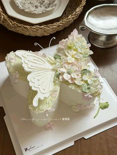 there is a cake shaped like a butterfly on top of a white plate with flowers