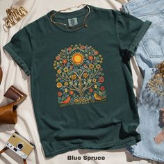 🌞 Embrace the beauty of nature with this Scandinavian Folk Art T-Shirt featuring vibrant sunshine, birds, and colorful floral patterns. Perfect for adding a touch of whimsical charm to your wardrobe! 🌸🕊️  Comfort Colors 1717 is a fully customizable tee made 100% with ring-spun cotton. The soft-washed, garment-dyed fabric brings extra coziness to your wardrobe while the relaxed fit makes it an excellent daily choice. The double-needle stitching throughout the tee makes it highly durable while Summer Crew Neck T-shirt With Bird Print, Summer Cotton Tops With Bird Print, Nature-inspired Crew Neck T-shirt For Summer, Botanical Style Green T-shirt With Graphic Print, Green Botanical T-shirt With Graphic Print, Botanical Green T-shirt With Graphic Print, Nature-inspired Short Sleeve T-shirt For Summer, Summer Nature-inspired Crew Neck T-shirt, Nature-inspired T-shirt With Plants Print For Summer