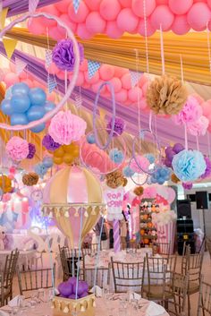 balloons and streamers are hanging from the ceiling in this party - like setting at a birthday party