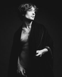 a man with no shirt on posing for a black and white photo