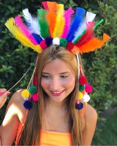 a girl wearing a colorful headdress with feathers